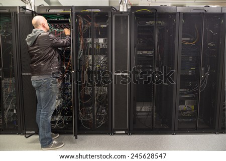 Network administrator working on cabling in a server cabinet