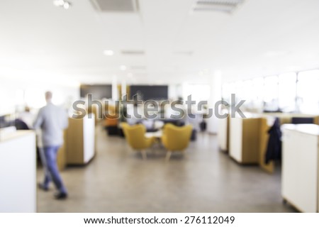 Blurry office with man out of focus walking away, great for use in designs for business or office settings