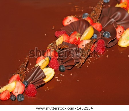 fancy chocolate cake with decorations made of fresh strawberries,blueberries and assorted berries, custom made chocolate decoration, very tasty looking