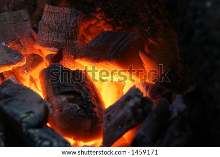 A craftsman/blacksmith working metal the oldfashioned way, shot of his stoking fire