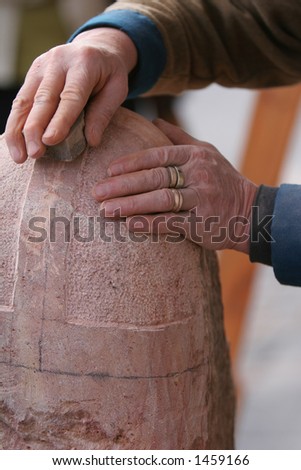 shot of craftsman working stone the old fashioned way with hammer and chisel
