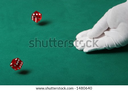 Dices being thrown in a craps game, or yatzee or any kind of dice involved game, Dices are a clear red color on a green felt table