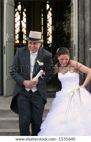 stock photo A real wedding bride and groom walking out the churchdoor 