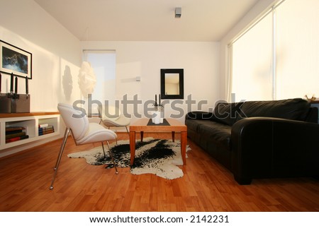 living room, with black leather sofa, mirror on wall, and photo, white chairs very trendy
