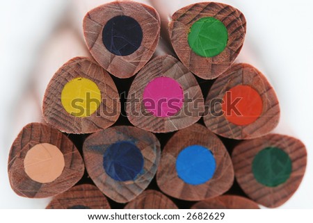 A macro shot of the back end of a group of colored pencils, isolated on white
