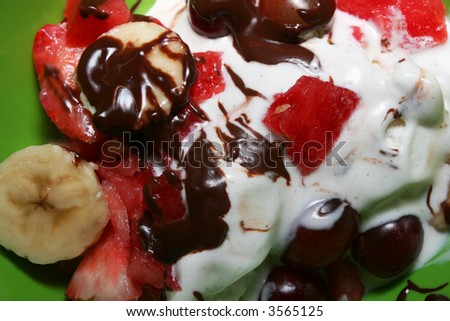 A close up of a vanilla ice cream sundae with banana and fudge sauce