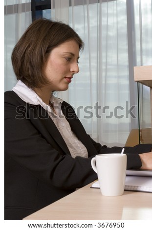 A young attractive businesswoman working on her laptop in a hotel suite