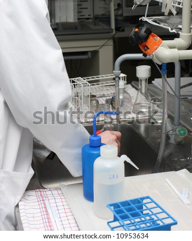 scientist working with chemicals and equipment in a real life pharmaceuticals laboratory