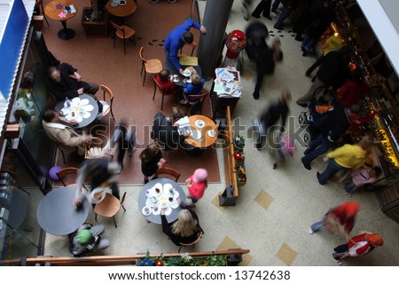 Shot of a busy cafe in a mall, people all motion blurred