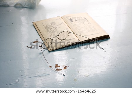 old fashioned reading glasses on top of an old book on a table