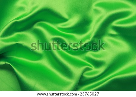 Green colored satin shot from above with creases and folds creating all sorts of shapes and shadows