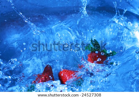 Fresh strawberries splashing into cold water, white balance deliberately set to custom to create feeling of cold and fresh.