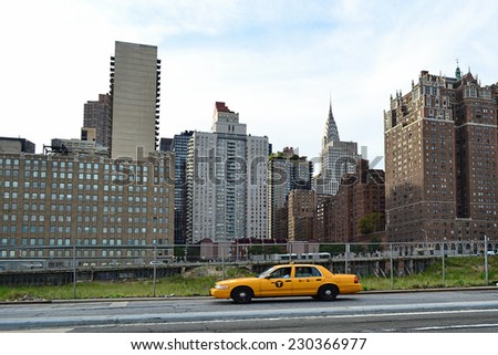NEW YORK- SEPTEMBER 14: View of Brooklyn neighborhood behind a NY yellow taxi travelling along the road in New York on September 14, 2014