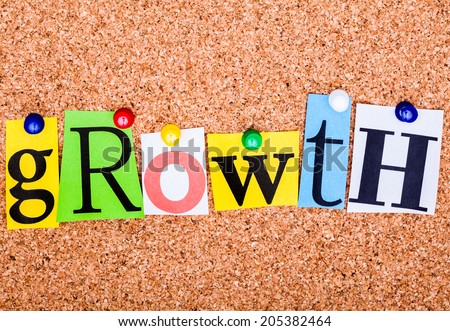 The word growth in cut out magazine letters pinned to a cork notice board