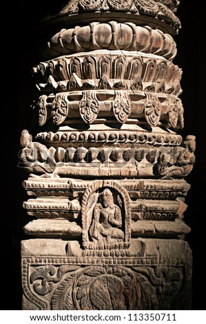 Hindu temple architecture detail. Wooden column with Nepali Hindu God (Vishnu avatar) figure and floral ornament. Nepal, Kathmandu