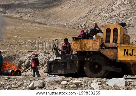 KHARDUNG LA PASS, INDIA - SEPTEMBER 12: Indian people working at road construction at Khardung La pass. The one main road at Himalaya mountains, altitude 5600 m. India, Ladakh, September 12, 2012