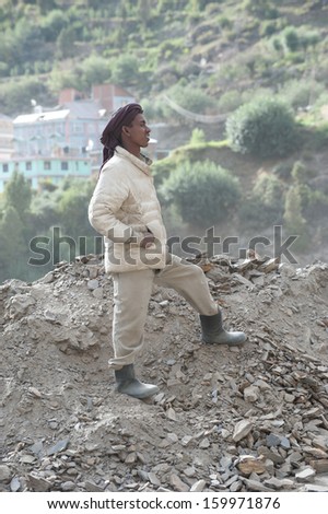 KEYLONG, INDIA - SEPTEMBER 06: Unidentified Indian man from poorest state Bihar,  working at road construction near Keylong village, Manali-Leh  highway. India, Himachal Pradesh, September 06, 2012