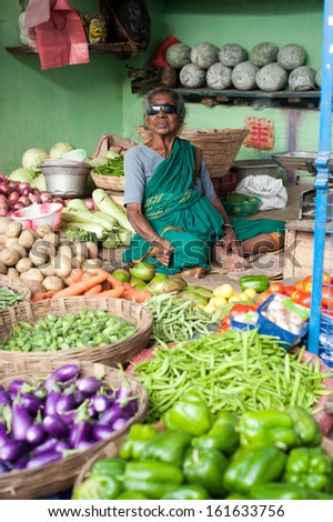 CHANNAI, INDIA - FEBRUARY 10: Indian woman selling greengrocery at market on February 10, 2013 in Chennai, India. Lot of different vegetables and herbs important ingredients of traditional Indian food