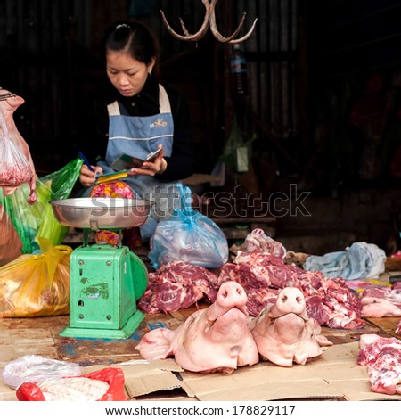 SIEM REAP, CAMBODIA - DEC 22, 2013: Unidentified Khmer woman selling meat at traditional food marketplace on Dec 22, 2013 in Siem Reap, Cambodia. Street food markets is popular tradition in asia