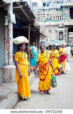 TRICHY, INDIA - FEBR 14:  Indian woman in colorful sari carrying bale on head at crowded street near Sri Ranganathaswamy Temple on Febr 14, 2013. India, Tamil Nadu, Thanjavur (Trichy)