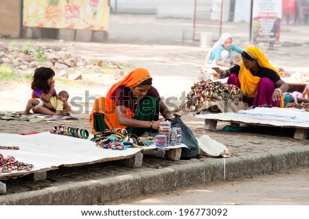 KOCHI, INDIA - FEBR 25: Unidentified Indian women in sari and their children sells souvenirs, bangles and cheap jewelry at street market place on Febr 25, 2013. Fort Cochin (Kochin),  Kerala, India