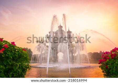 Sunset view of Patuxai arch or Victory Triumph Gate monument with fountain in front.  Vientiane, Laos travel landscape and destinations