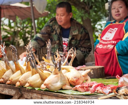 LUANG PRABANG, LAOS - DEC 8: Unidentified people selling meat at traditional food marketplace on Dec 8, 2013 in Luang Prabang, Laos