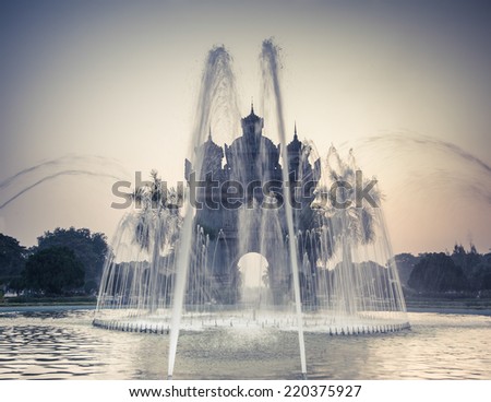 Sunset view of Patuxai arch or Victory Triumph Gate monument with fountain in front.  Vientiane, Laos travel landscape and destinations