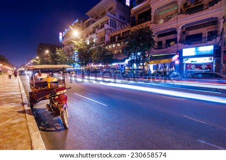 PHNOM PENH, CAMBODIA - DEC 29, 2013: Moto taxi at asian city. Scene of night life at most popular tourist street near Mekong river in capital city Phnom Penh, Cambodia