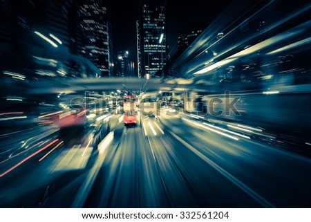 Abstract cityscape traffic background with motion blur, art toning. Moving through modern city street with  illuminated skyscrapers. Hong Kong