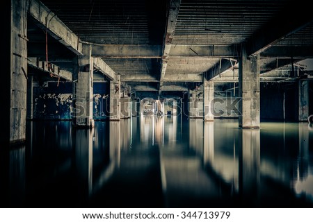Dramatic view of damaged and abandoned building sunken by rain flood waters. Apocalyptic and evil concept