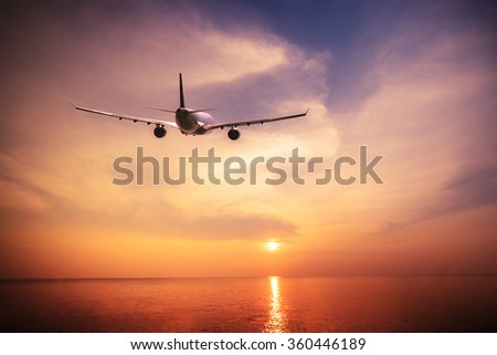 Airplane flying over amazing tropical ocean at  sunset. Thailand travel  landscapes and destinations