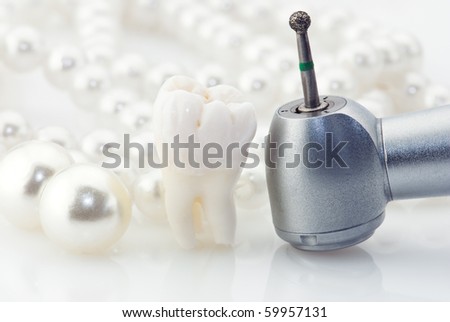 Wisdom tooth natural pearls and dental drill.