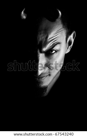 Low key portrait of evil. Dark portrait of devil looking man with horns