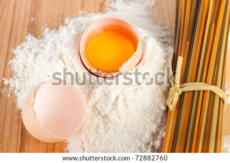 Bakery ingredient. Flour with eggs and pasta on wooden background