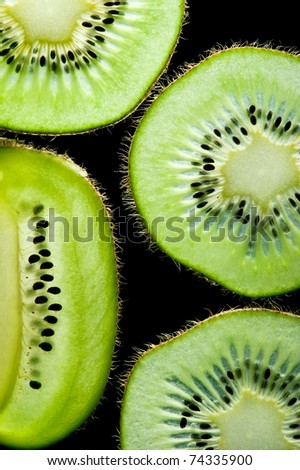 Macro of slim sliced kiwi fruit on black background