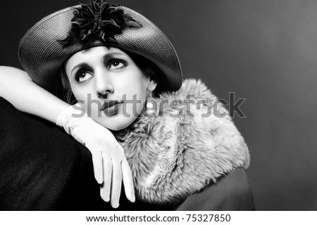 Retro styled fashion portrait of a young woman in hat. Clothing and make-up in vintage style - stock photo