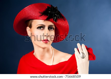 Retro style imitating fashion portrait of a young woman in red hat. Clothing and make-up in vintage style