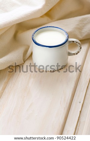 Breakfast with milk. Milk in vintage cup on old wooden table with linen tablecloth