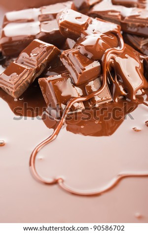 Chocolate background. Broken bars and flowing liquid chocolate