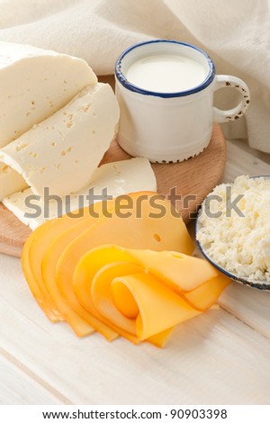 Breakfast with milk and cheese on old wooden table with linen tablecloth