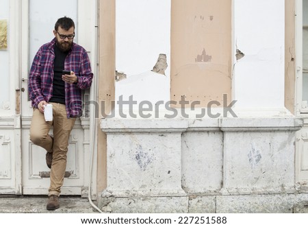 Man With Beard And Glasses Holding Phone And To Go Cup