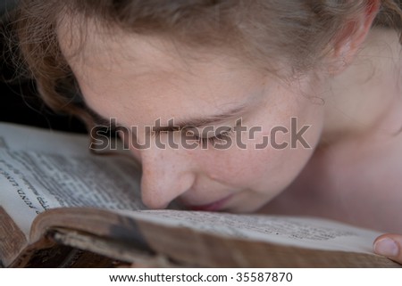 portrait of a young woman putting her nose in a book as a student