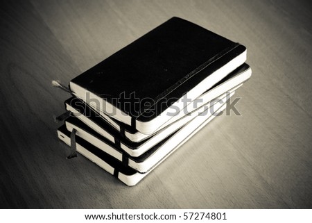 stack of black notebooks, vintage monochrome