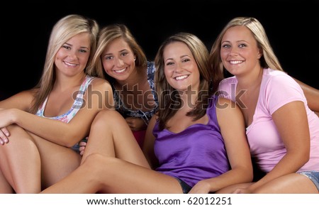 four beautiful sisters sit on the couch together.