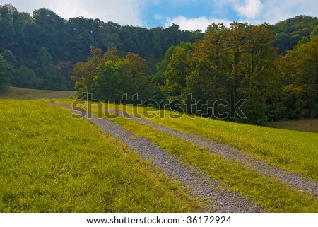 sweeping country farm road in West Virginia hills.