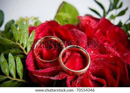 stock photo Closeup of two golden wedding rings on flowers