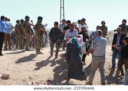 SURUC, TURKEY-SEPTEMBER 20, 2014: Turkey opened its border to Syrians fleeing the town of Kobane in fear of an Islamic State attack. Tens of thousands have fled to Turkey on september 20, 2014.