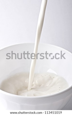 The milk flowing into the cup .