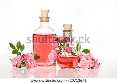 Spa set with rose. rose petals oil , Perfumed Rose Water in glass bottles small pink roses with leaves . Massage, aromatherapy and organic cosmetics concept